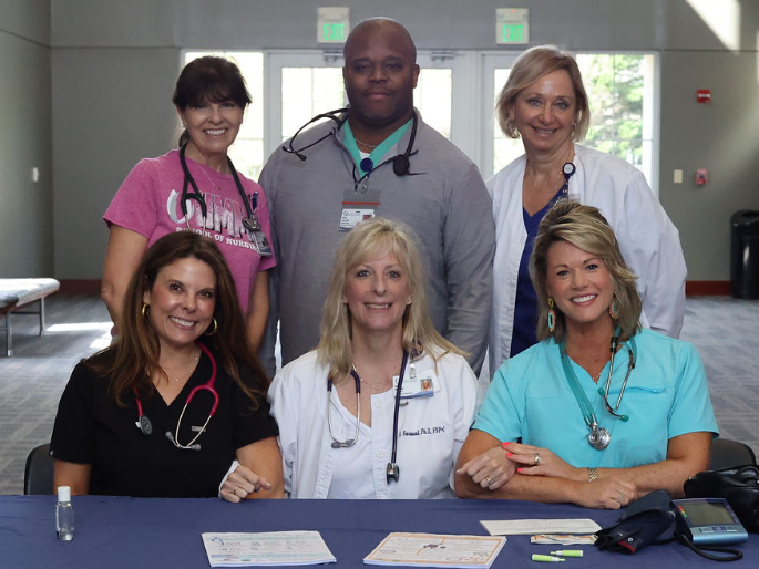 nursing faculty and nurse educators pose for a group photo during a health screening